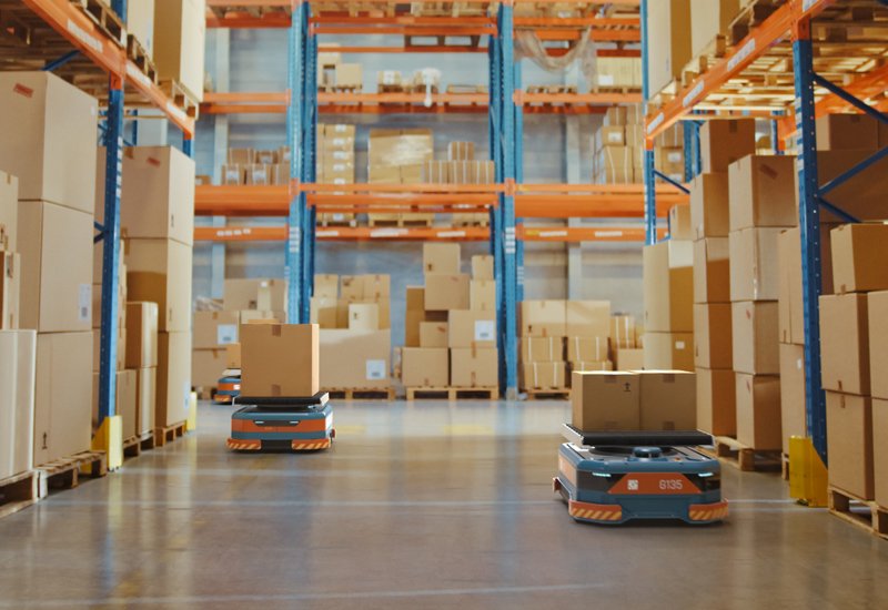 Future Technology 3d Concept: Automated Modern Retail Warehouse Agv Robots Transporting Cardboard Boxes In Distribution Logistics Center. Automated Guided Vehicles Delivering Goods, Products, Packages